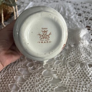 Pu&ograve; includere: Brocca in ceramica bianca con un motivo floreale marrone e un marchio marrone sul fondo che recita "Rugby Aunt China G&C."