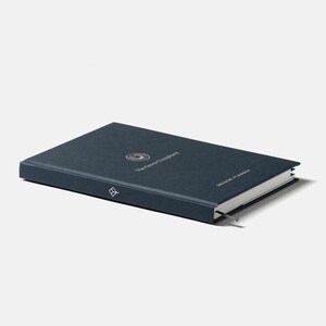 May include: A dark blue hardcover journal with a silver logo and the text "The Known Universe" and "Garden Planner".