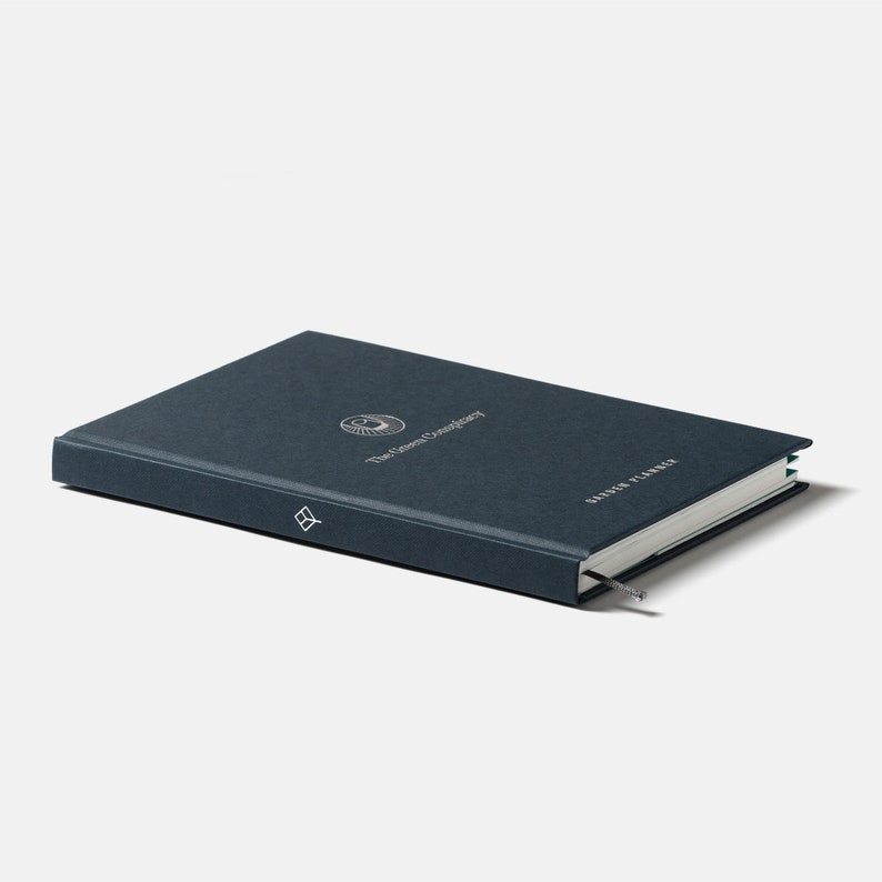 May include: A dark blue hardcover journal with a silver logo and the text "The Known Universe" and "Garden Planner".