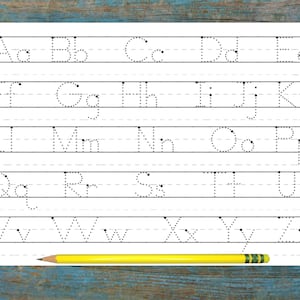 May include: A black and white printable worksheet with dotted lines for tracing the alphabet. The worksheet is on a light blue wooden surface with a yellow pencil on top of the paper.
