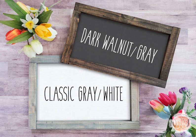 Op de afbeelding: Twee houten ingelijste borden met verschillende kleurcombinaties. Het bovenste bord is donkerwalnoot met grijze tekst die "DARK WALNUT/GRAY" luidt. Het onderste bord is klassiek grijs met witte tekst die "CLASSIC GRAY/WHITE" luidt.