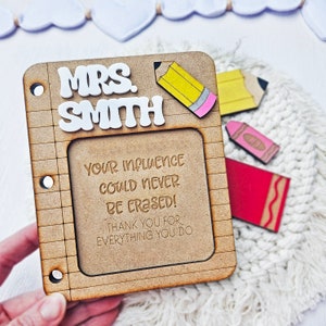 May include: A wooden teacher appreciation plaque with the text "MRS. SMITH YOUR INFLUENCE COULD NEVER BE CRASED! THANK YOU FOR EVERYTHING YOU DO" and a pencil and crayon design.