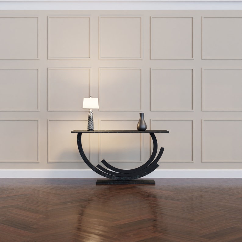 K&ouml;nnte beinhalten: Ein schwarzer Konsolentisch mit einem geschwungenen, abstrakten Design. Der Tisch hat eine dunkelbraune Tischplatte und ist mit einer wei&szlig;en Lampe und einer schwarzen Vase dekoriert.