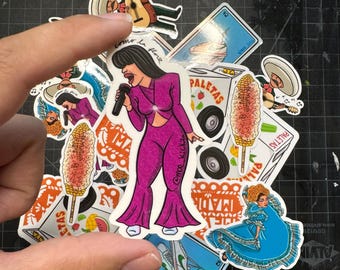 May include: A collection of colorful stickers featuring a woman singing, a corn on the cob, a paleta cart, and a woman in a blue dress. The stickers are on a black and white grid background.