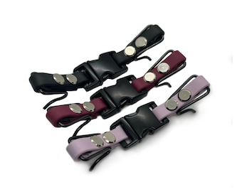 May include: Three adjustable straps with black buckles and silver metal accents. The straps are black, burgundy, and lavender.