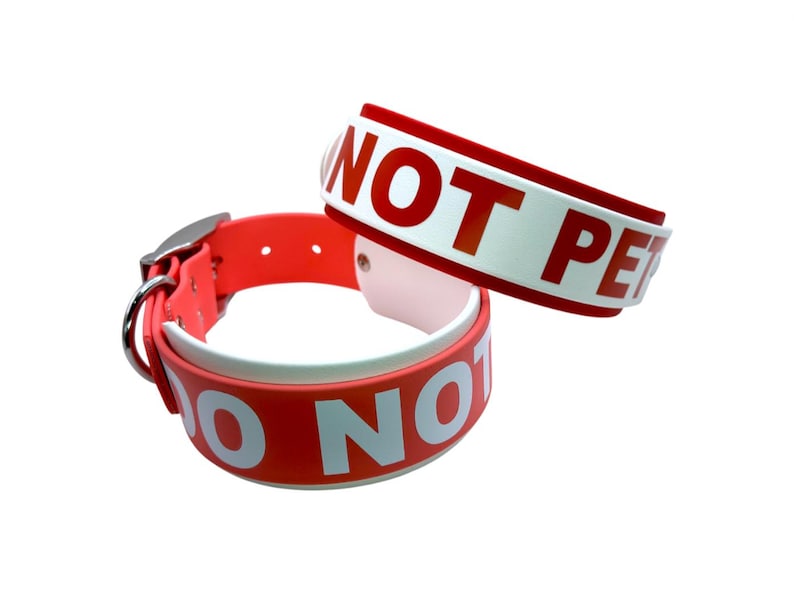 May include: Two red dog collars with white lettering. The top collar says "Do Not Pet" and the bottom collar says "Do Not Pet".