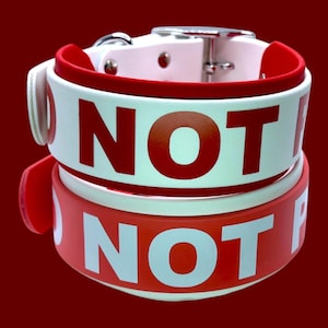 May include: Two red and white dog collars with the text "NOT FOR" printed on them.