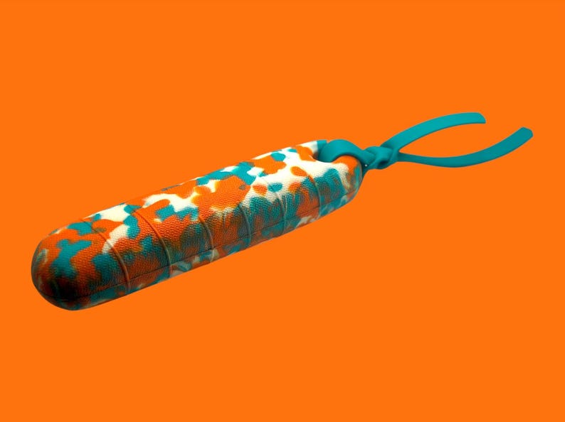 K&ouml;nnte beinhalten: Ein zylindrisches Massageger&auml;t mit strukturierter Oberfl&auml;che, das mit orangefarbenen, t&uuml;rkisfarbenen und wei&szlig;en Flecken gemustert ist. Es hat t&uuml;rkisfarbene Griffe und ist vor einem orangefarbenen Hintergrund platziert.