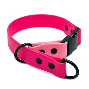 May include: Pink and light pink dog collar with a black buckle and D-ring. The collar is made of a soft, flexible material.