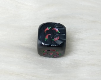 May include: Black dice with red chili pepper illustrations.