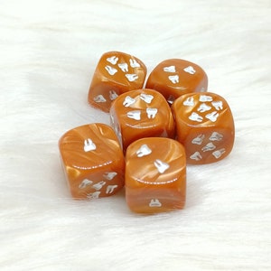 May include: Six orange dice with white tooth designs. The dice are made of a translucent material and have a swirl pattern.