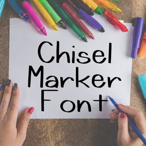 May include: A white sheet of paper with the words "Chisel Marker Font" written in black marker. The paper is surrounded by colorful markers.