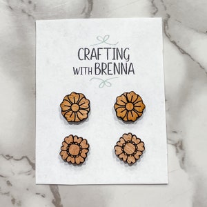 Puede incluir: Cuatro pendientes de madera en forma de flor en una tarjeta blanca con el texto "CRAFTING WITH BRENNA".
