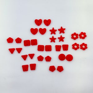 May include: A collection of red felt shapes, including hearts, stars, flowers, and geometric shapes. These shapes are perfect for crafting, scrapbooking, or adding a touch of whimsy to any project.