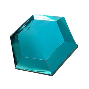 Puede incluir: Una caja de color turquesa, de forma geométrica, con una superficie brillante y reflectante. La caja tiene múltiples facetas, lo que le da una apariencia de gema. Los bordes están bien definidos y el diseño general es moderno y llamativo.