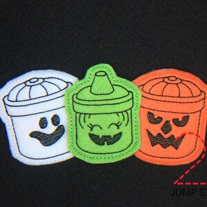May include: Three felt Halloween-themed treat containers. One is white with a smiling face, one is green with a smiling face, and one is orange with a jack-o'-lantern face. The containers are stitched together with a jump stitch.