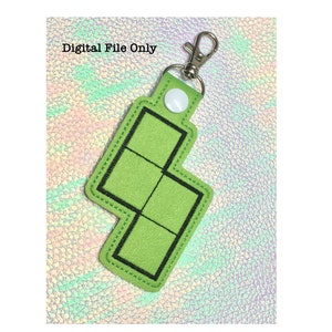 May include: Green felt keychain shaped like a Tetris block with black stitching and a silver key ring. "Digital File Only" is written in white text on a white background.