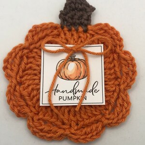 May include: Handmade crocheted orange pumpkin with a brown stem and a tag that says "handmade pumpkin".