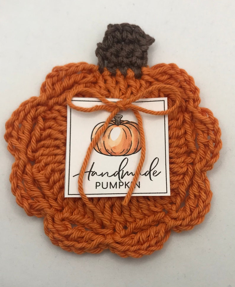 May include: Handmade crocheted orange pumpkin with a brown stem and a tag that says "handmade pumpkin".