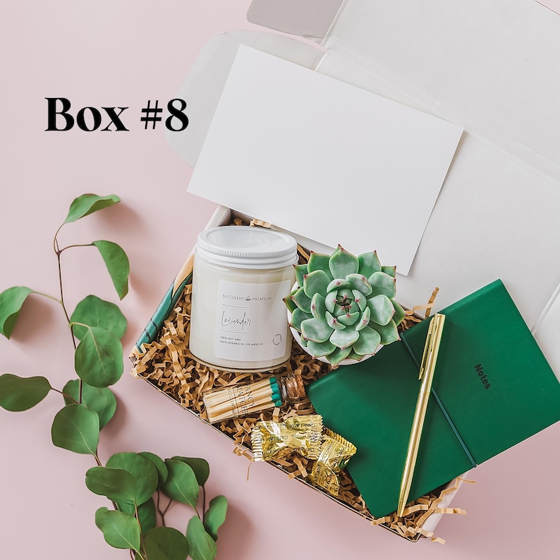a box with a plant, a candle, and a notepad