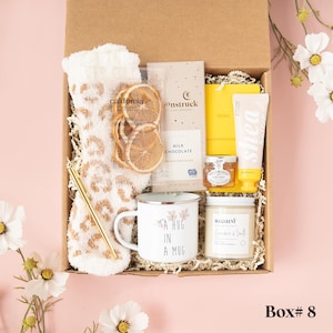 a box with a cup, a mug, a towel, and some other items