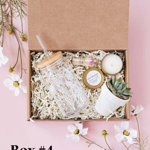 a box containing a candle, a glass jar, and a plant