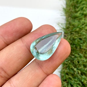 May include: A teardrop-shaped aquamarine gemstone with a light blue color.