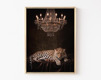 Könnte beinhalten: Gerahmter Druck mit einem Leoparden, der auf einer drapierten Oberfläche unter einem Kristallleuchter ruht. Der Leopard hat ein geflecktes Fell, und der Kronleuchter ist vor einem dunklen Hintergrund beleuchtet.