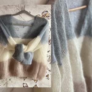 May include: A soft, light blue, white, and pink striped knit sweater with a V-neck.