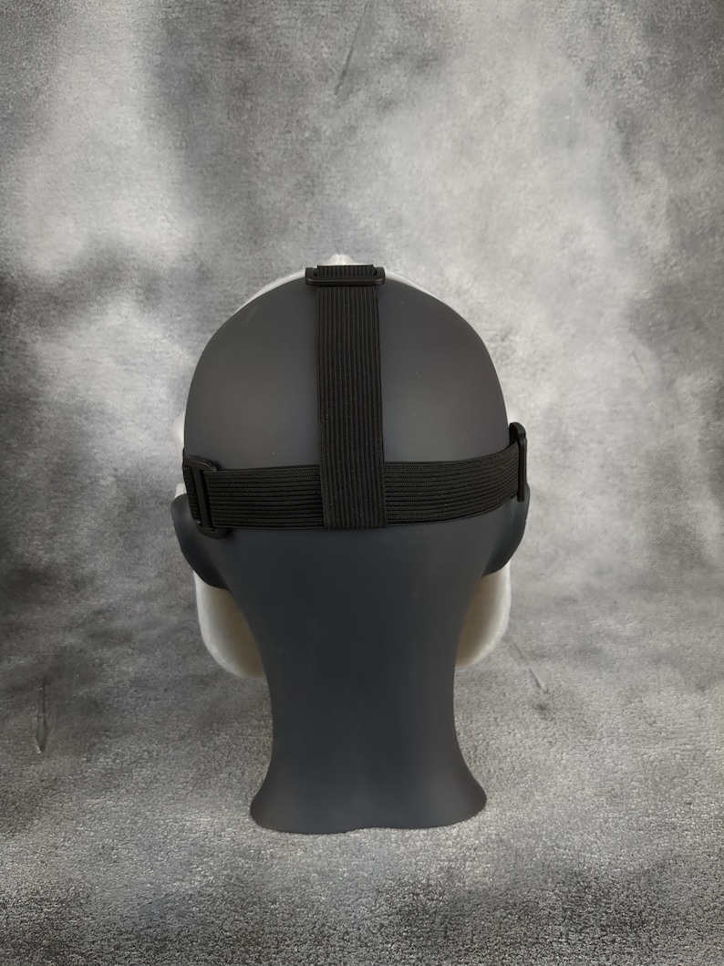 May include: A white and black mask with an adjustable strap. The mask is made of a smooth, flexible material and has a realistic appearance.