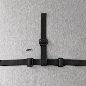 May include: Black elastic strap assembly with three buckles and a small pile of screws. The straps are arranged in a T-shape against a grey background. The buckles are square and made of black plastic.