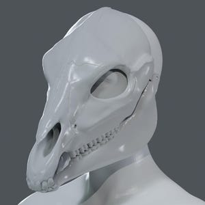 May include: A light gray, stylized skull mask, resembling a horse or similar animal. The mask features detailed bone structure, including eye sockets, teeth, and nasal passages. The mask is designed to fit over the face and head.