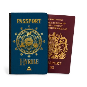 Może przedstawiać: Niebieski pokrowiec na paszport z złotym wzorem przedstawiającym Triforce i napisem "PASSPORT" oraz "HYRULE".