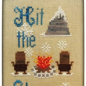 May include: Cross-stitch pattern with the text "Hit the Slopes" in blue, a mountain in gray, two brown chairs, and a red and orange fire.