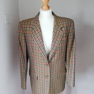 May include: A brown, black and red checked blazer with a single button fastening.