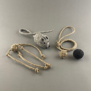 May include: A set of cat toys featuring a gray felt mouse, a black felt ball, and three knotted rope toys.
