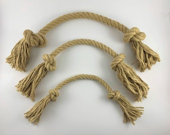 May include: Three natural rope dog toys of varying sizes. The ropes are knotted at the ends and have frayed ends, creating a textured surface.