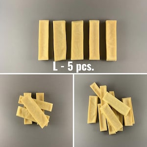 Puede incluir: Cinco palitos masticables largos, rectangulares y de color marrón claro dispuestos en fila. El texto "L - 5 pcs." está debajo de los palitos.