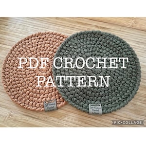 Peut inclure: Deux dessous-de-verre en crochet, l'un de couleur brun clair et l'autre de couleur vert foncé. Les dessous-de-verre sont ronds et ont une surface texturée. Le texte "PDF CROCHET PATTERN" est écrit en lettres blanches sur fond noir. Le texte "Get Hooked Crochet by Chris" est écrit sur une petite étiquette attachée à chaque dessous-de-verre.