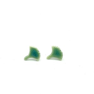 May include: A pair of green ceramic earrings shaped like ginkgo leaves.