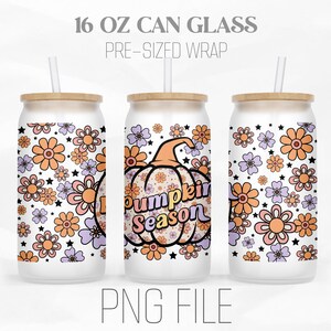 May include: A white 16 ounce can glass with a pre-sized wrap featuring a pumpkin with the text "Pumpkin Season" and a floral pattern in shades of orange, pink, and purple.