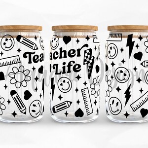 May include: Three glass jars with wooden lids, each decorated with a black and white pattern of stars, hearts, lightning bolts, pencils, rulers, smiley faces, and flowers. The middle jar has the text "Teacher Life" in black.