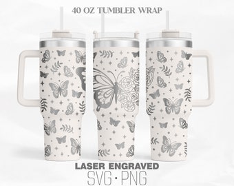 Op de afbeelding: Een witte 40 ounce tumbler met een zilveren vlinder- en bloemenontwerp. De tumbler heeft een handvat en een deksel met een rietje. De tekst "LASER ENGRAVED SVG. PNG" staat onderaan de afbeelding.