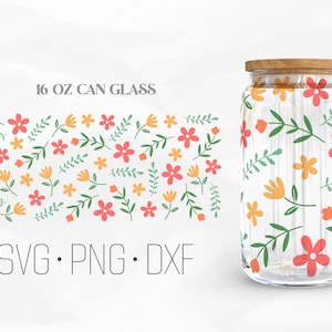 Puede incluir: Un vaso de cristal transparente de 473 ml con un patrón floral en tonos rojos, amarillos y verdes. El texto "SVG. PNG. DXF" está impreso debajo del vaso.