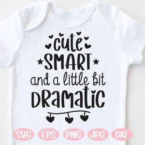 May include: White baby onesie with black text that reads "cute: *SMART* and a little bit Dramatic" with hearts above and below the text and a string of hearts at the bottom. The onesie is available in SVG, EPS, PNG, JPG, and DXF formats.
