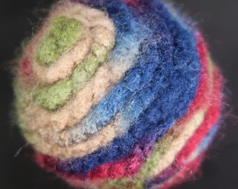 May include: A colorful, hand-felted ball with a spiral pattern in shades of blue, green, pink, and beige.