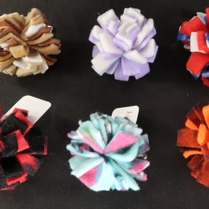 May include: Assortment of colorful felt pom-poms, each with a different pattern and color combination. The pom-poms are made of soft, fluffy felt and are perfect for adding a touch of whimsy to any project.