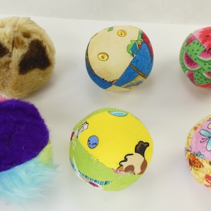 May include: Six colorful fabric balls with different patterns. The balls are made of soft fabric and are perfect for playing with pets.