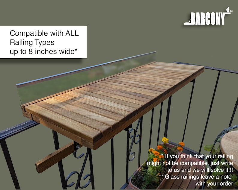 Pode incluir: Uma mesa de varanda de madeira, fixada a uma grade de metal preta. A mesa &eacute; feita de t&aacute;buas de madeira marrom claro e foi projetada para caber em grades de at&eacute; 20 cm de largura. O texto "Compatible with ALL Railing Types up to 8 inches wide*" &eacute; vis&iacute;vel.