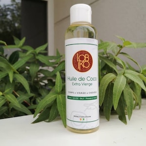 Puede incluir: Una botella de vidrio transparente con una tapa blanca que contiene aceite de coco extra virgen. La etiqueta es blanca con acentos verdes y marrones y dice "Huile de Coco Extra Vierge" y "CORPS VISAGE CHEVEUX 100ml - 5.3 OZ - Brut - Pressé à froid" en francés. La etiqueta también incluye el texto "Made in Côte d'Ivoire" en inglés.
